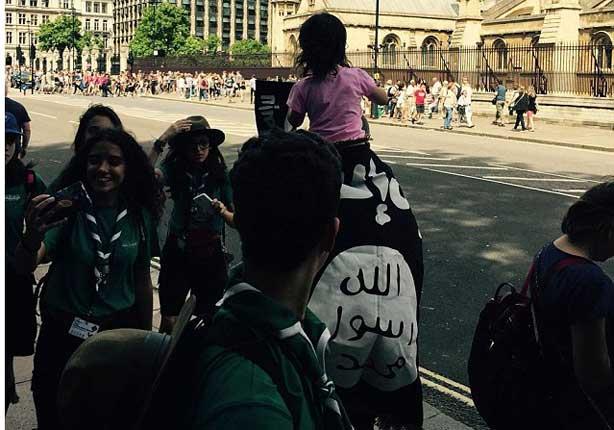  رجل بريطاني يحمل طفله ملتف بعلم تنظيم داعش                                                                                                                                                             