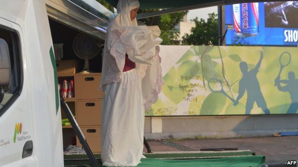 امرأة مسلمة تؤدي الصلاة في "المسجد المتنقل"                                                                                                                                                             