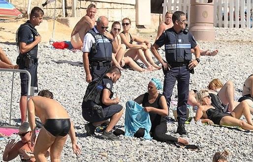  الشرطة الفرنسية تجبر امرأة على خلع البوركيني ودفع الغرامة (1)                                                                                                                                          