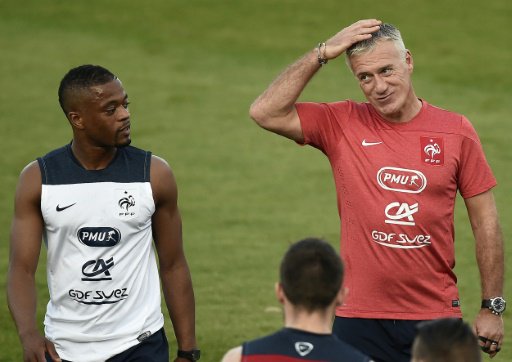 مدرب المنتخب الفرنسي لكرة القدم ديدييه ديشان (الى اليمين) وقائده السابق باتريس إيفرا، خلال حصة تدريبية خلال كأس العالم في البرازيل، في 22 حزيران/يونيو .2014