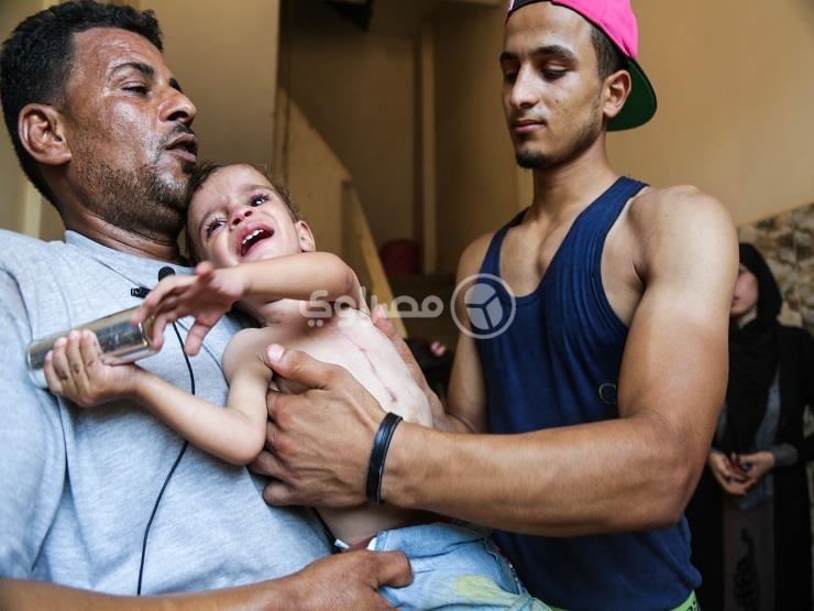الطفل محمود أيمن يحمل فارغ الخرطوش.                                                                                                                                                                     
