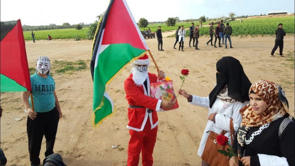 فلسطيني يوزع ورود على حدود غزة بملابس سانتا كلوز (1)                                                                                                                                                    