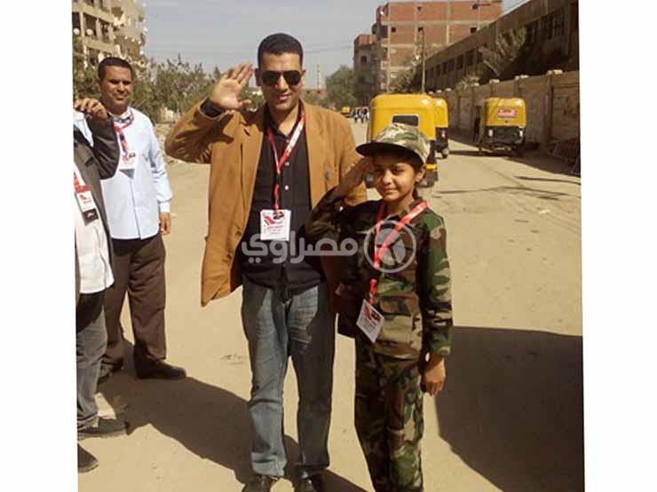 طفلة ترتدي بدلة جيش بصحبة والدها في الانتخابات (1)                                                                                                                                                      