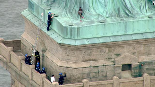 امرأة تتسلق تمثال الحرية الأمريكي  (1)                                                                                                                                                                  