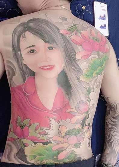 رجل يرسم صورة حبيبته بالوشم على ظهره