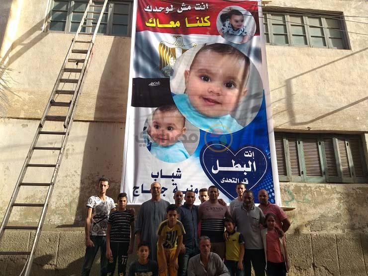 صورة تجمع أهالي القرية امام لافتة الطفل