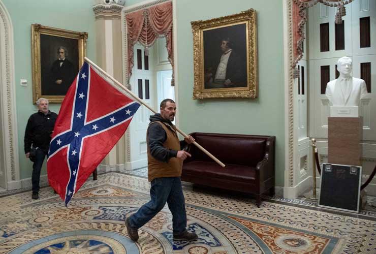 أحد مؤيدي ترامب يحمل علم معركة الكونفدرالية في مبنى الكابيتول روتوندا