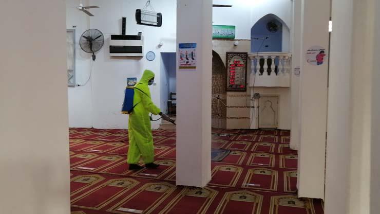 أحد المتطوعين يعقم فرش المسجد