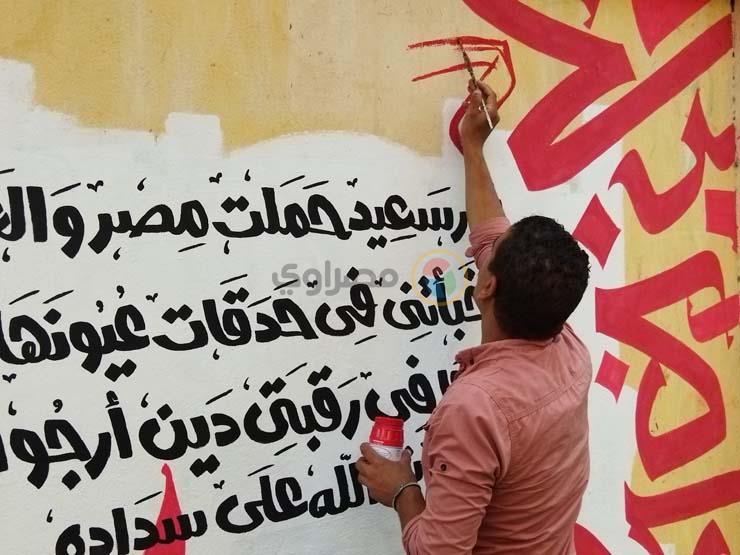 شاب يزين أسوار المدارس في بورسعيد بالجرافيتي