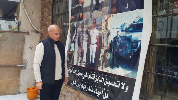 حافظ شوشة أمام صورة لأبنه بالزي الميري واثناء التدريبات 