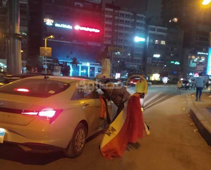 أم مصطفى تساعد زوجها في بيع الأعلام قبل مباراة مصر