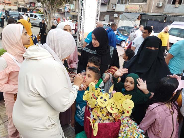 شباب يرسمون على وجوه الأطفال احتفالا بالعيد في بورسعيد