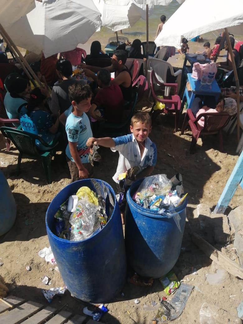 أطفال يجمعون القمامة على شواطئ الإسكندرية