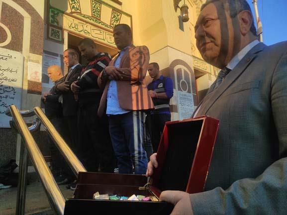 مواطن مسيحي يحمل الشيكولاتة  انتظارا لانتهاء صلاة العيد