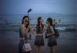 نساء صينيات يأخذون صورة سيلفي على شاطئ تشينغداو، في شرق الصين، 14 يوليو 2015                                                                                                                            