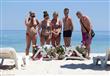 سياح ينظرون لزهور موضوعة في مواضع  جثث ضحايا الهجوم الإرهابي على أحد الشواطئ جنوب تونس