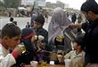 أفغاني يصب لامرأة وبعض الأطفال مشروبا حلوا في مدينة قندهار في أفغانستان                                                                                                                                 
