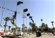 عمال يعلقون الأعلام الليبية في ساحة الشهداء بطرابل