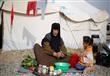 نازحة تعد الطعام في مخيم حسن شام لإيواء الأسر العر