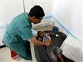 طبيب يمني يفحص طفلا يشتبه باصابته بالكوليرا في احد