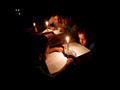 أطفال فلسطينيون يقرأون كتبهم على ضوء الشموع بسبب ن