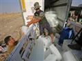 عراقيون يفرغون قوالب ثلج من شاحنة في تل عبطة جنوب 