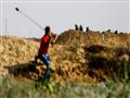 فلسطيني يرشق جنودا إسرائيليين بالحجارة خلال مواجها