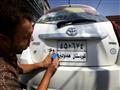 عراقي كردي يضع ملصقا على لوحة سيارة كتب عليه بالكر