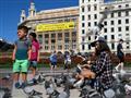 امرأة وبعض الاطفال في احدى ساحات برشلونة امام مبنى