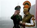جندي صيني (يسار) يقف الى جانب جندي هندي في معبر نا