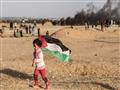 طفل فلسطينية ترفع العلم الفلسطيني قرب الحدود بين إ