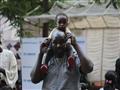 أحد المشاركين في اليوم العالمي للاجئين بصحبة طفله