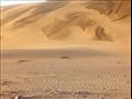 منظر يوضح تطاير الكثبان الرملية من جبال الرمال بمر