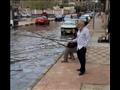 مواطنون يصطادون بشوارع بورسعيد للسخرية من تراكم المياه٧