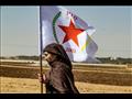 امرأة كردية في سوريا تلوح بعلم حزب الاتحاد الديموق