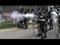 شرطي يطلق الغاز المسيل للدموع على المتظاهرين في هو