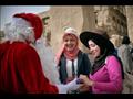 بابا نويل يوزع الهدايا والورود على السائحين في معبد الكرنك 