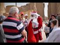 بابا نويل يوزع الهدايا والورود على السائحين في معبد الكرنك 