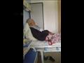 الزوج خلال مرضه على سرير بمستشفى سيدي غازي بجوار زوجته