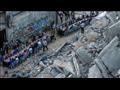 عائلات فلسطينية تتناول الإفطار بجانب مبنى دمرته غا