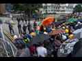 المتظاهرون يستخدمون المظلات الشمسية في مواجهة الغاز المسيل للدموع