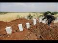رجل سوري يضع حجرا ابيض على قبر احد ضحايا غارات قوا