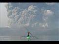شخص في قارب بينما يتصاعد الرماد من بركان تال جنوب 