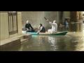 اهالي يستخدمون قارب لعدم سيرهم في الشوارع بسبب مياه الأمطار