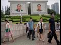  مارة أمام صور الزعيمين الكوريين الشماليين الراحلي