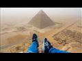 مصري يتسلق قمة الأهرامات