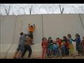 أطفال سوريون يتسلّقون الجدار الحدودي الذي شيّدته ت