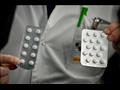 موظف يحمل حبوب دواء كلوروكين في معهد "ميديتيرانيه"