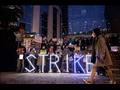 أعضاء في تحالف موظفي هيئة المستشفيات الصينية وناشطون في مبنى الهيئة بهونج كونج يقفون حاملين لوحات مُضيئة بأحرف كلمة إضراب بالإنجليزية 7 فبراير