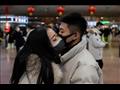 زوجان يُقبّلان بعضهما أثناء سفرهما لقضاء عطلة رأس السنة القمرية الجديدة في بكين يوم 24 يناير